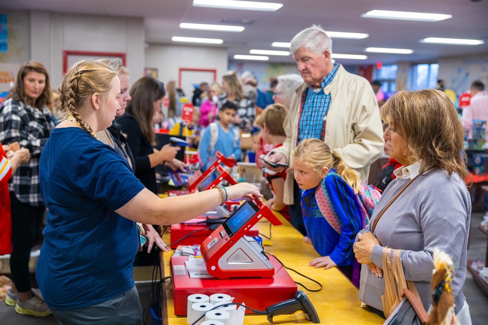 people buying books from the librarian at the book fair